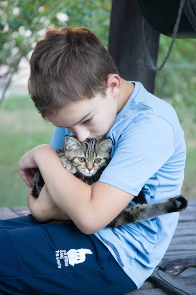 a boy hugs a cat, a happy child holds a cat in his arms