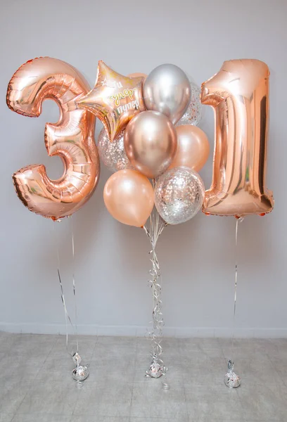 set of pink helium balloons on the wall background, foil number balloons