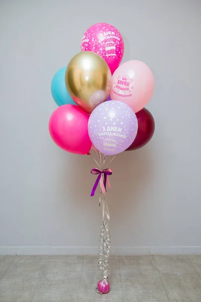 A set of colorful balloons on the background of the wall, helium balloons, the inscription on the balloons \