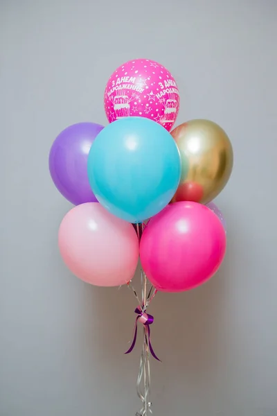 A set of colorful balloons on the background of the wall, helium balloons, the inscription on the balloons \