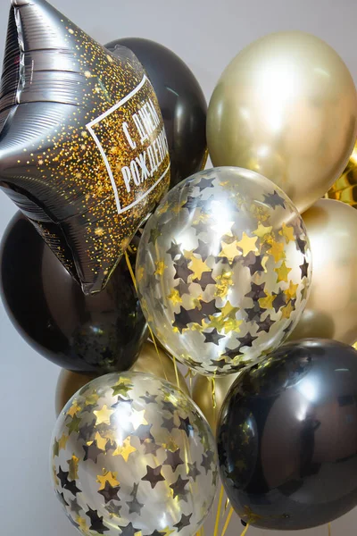 black and gold birthday balloons, a set of helium balloons, the inscription on the balloon 