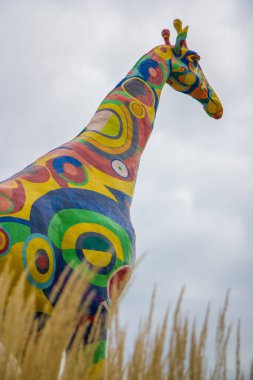 Çimen tarlasında çok renkli bir zürafa figürü