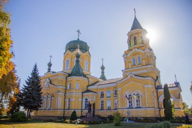 Sarı kilise batan güneşin arka planına karşı.