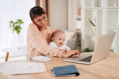 Bekar bir anne bebeğini kucağında tutarken ve dizüstü bilgisayar kullanırken telefona cevap veriyor. Mutlu çoklu görev yapan iş anneleri evde çalışırken müşterileriyle plan yapıyor. Annelik ve anneliği dengeleyen yeni anne