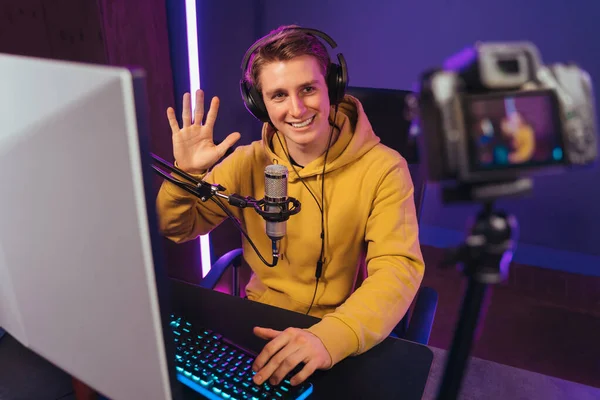 Pro gamer vlogger recording video on camera while playing video games at night