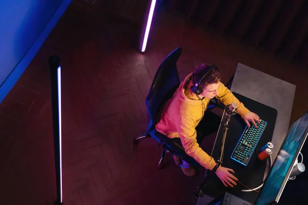 Top view of cyber sportsman playing computer game at home in neon color —  Fotos de Stock