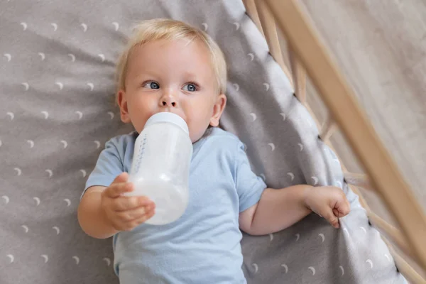 Upper View Adorable Baby Boy Holding Bottle Formula Lying Crib — Stock Photo, Image