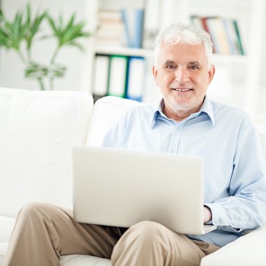 Dizüstü bilgisayar kullanan kıdemli adam.