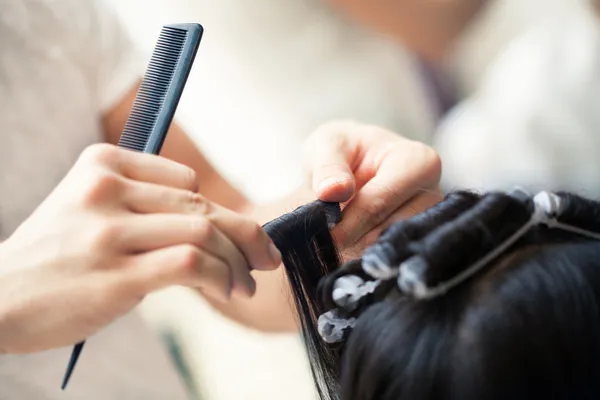 Friseur setzt Curler ein — Stockfoto