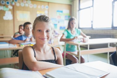 liseli kızlar sınıfta otururken gülümseyen