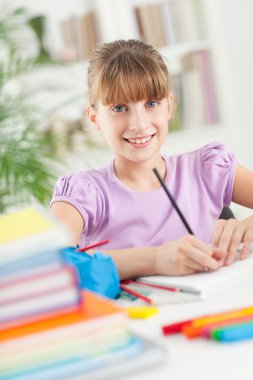 gülümseyen kız ödevini evde yapıyor