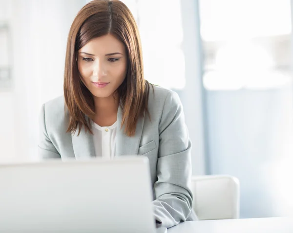 Sorridente imprenditrice al suo computer portatile — Foto Stock