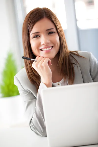 Sourire femme d'affaires à son ordinateur portable — Photo