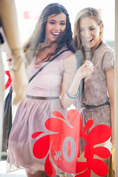 Dos mujeres sonrientes ventana de compras — Foto de Stock