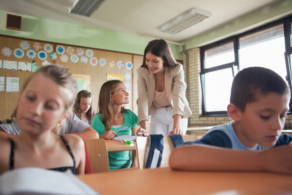 Primary School Teacher Helping Students