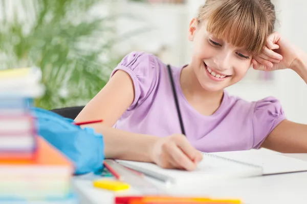 Usmívající se dívka dělat domácí úkoly — Stock fotografie