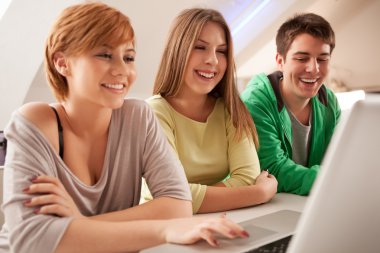 bir dizüstü bilgisayar kullanarak genç gülümseyen