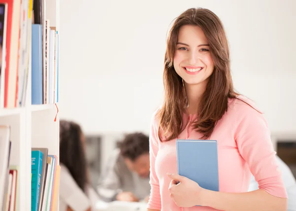 Sorrindo mulher segurando um livro — Fotografia de Stock