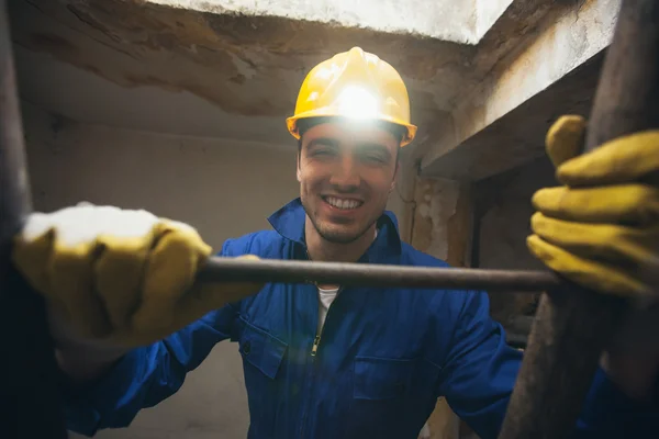 Travailleur de la construction souriant grimpant une échelle — Photo
