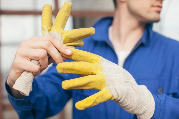 Construtor tirando luvas de proteção — Fotografia de Stock