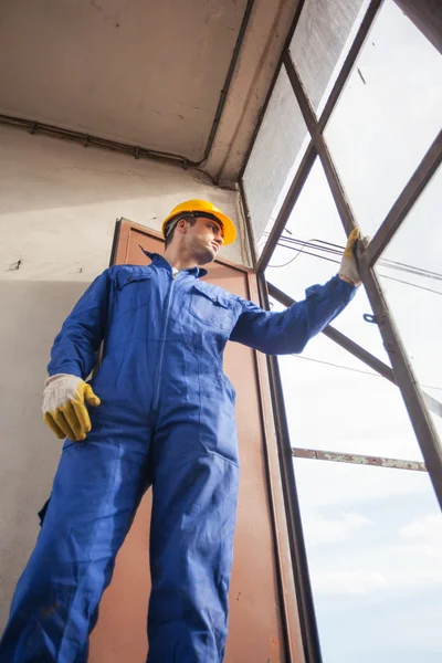 Travailleur de la construction regardant par une fenêtre — Photo