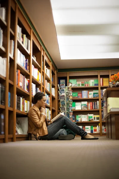 Vrouw leest op een boekenwinkel — Stockfoto