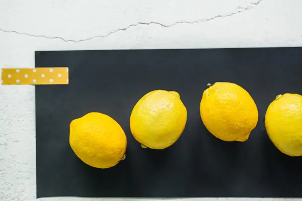 Limões em uma superfície preta — Fotografia de Stock