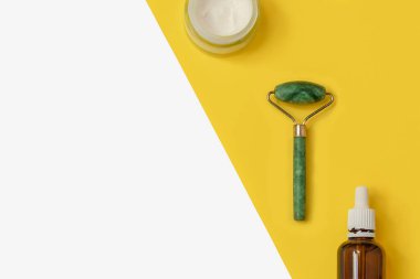 Yeşim taşlı, yüz kremi, iki renk sarı ve beyaz arkaplanlı serum.