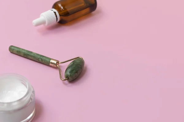 Jade-Gesichtswalze für die Beauty-Gesichtsmassage-Therapie. Beauty-Tools auf pastellrosa Hintergrund — Stockfoto