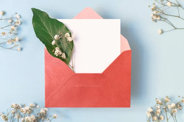 Floral composition with envelope and blank white card and white flowers, top view — Stock Photo, Image