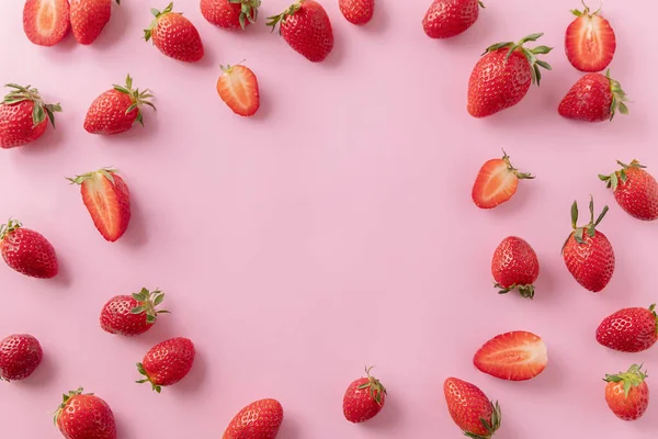 Juicy ripe strawberries on pink background, top view. Strawberry frame, copy text