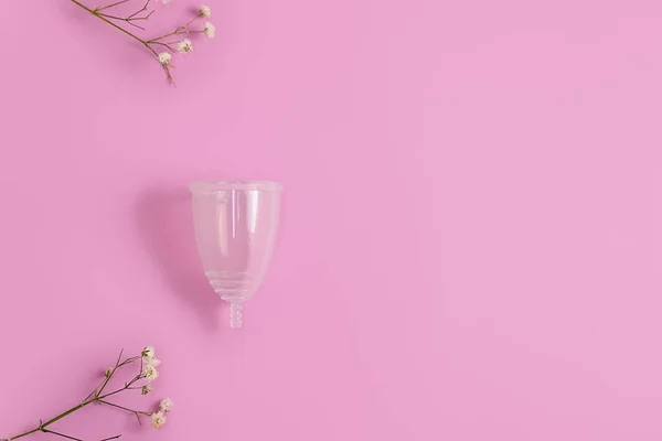 Ovanifrån av silikon menstruation kopp. med blommor på pastell rosa bakgrund, kopiera utrymme. — Stockfoto