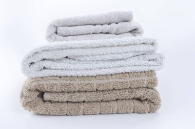 Stack of folded clean soft towels on white