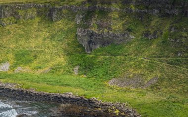 Uçurumun tepesinden, Vahşi Atlantik Yolu 'ndan ve UNESCO dünya mirasından Kuzey İrlanda' da görülen Giants Causeway 'deki Amfitiyatroya hayran turistler