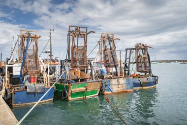 Howth Limanı, Dublin, İrlanda 'da dört küçük balıkçı teknesi ve kabuklu deniz hayvanı kafesleri