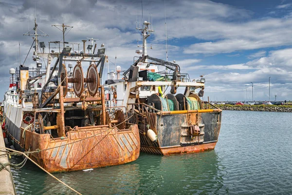 Howth limanında demirlemiş iki eski ve paslı balıkçı teknesi, Dublin, İrlanda