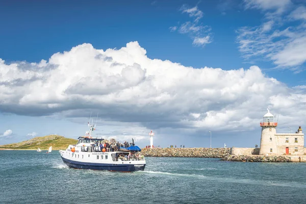 Gruppo di persone su una barca tour nel porto turistico di Howth con Howth Lighthouse e Irelands Eye Island sullo sfondo — Foto Stock