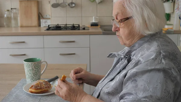 Senior Woman Eats Donut Breakfast — Stok fotoğraf