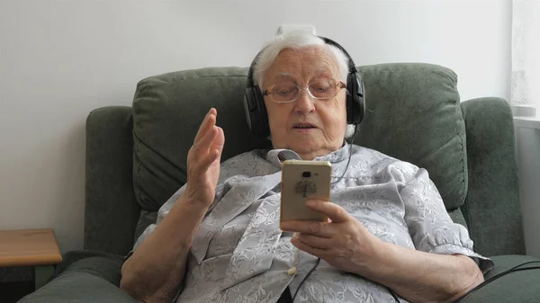 Yaşlı Kadın Bir Akıllı Telefonda Müzik Eski Hit Dinliyor — Stok fotoğraf