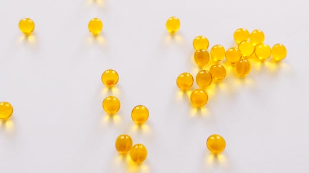黄色の錠剤にビタミンD Eまたはオメガ3魚油 白い背景に金色のカプセル ビタミンD Eまたはオメガ3魚油の概念 — ストック動画