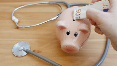 Masada tıbbi steteskop ve kumbara var. Sağlık sigortasına yatırım 