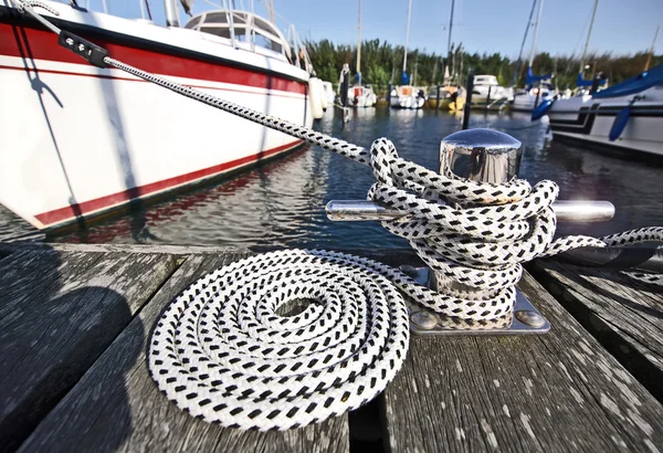 Getty rope in the harbor with yacht — Stock Photo, Image