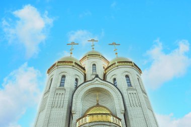 Altın kubbeli ortodoks tuğla kilise ve güzel bulutlu gökyüzünün zemininde 3 haç.