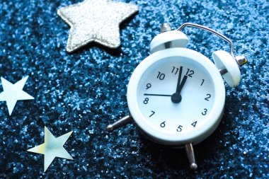 Yıldızlı, siyah, parlak bir arka planda beyaz çalar saat. Uykusuzluk kavramı