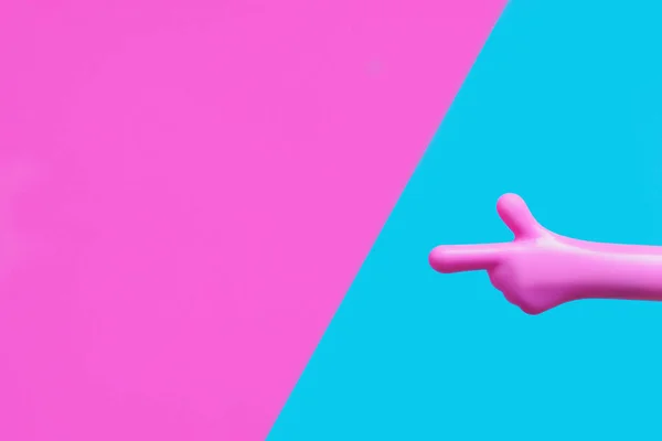 亮粉色塑料手 食指指向粉蓝色背景 复制空间 — 图库照片