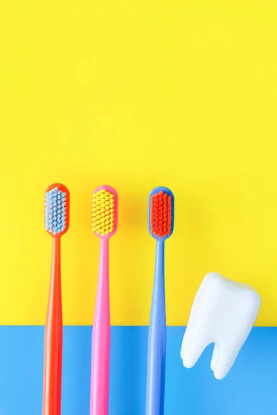 Three Multi Colored Toothbrushes Figurine Tooth Blue Yellow Background Dentistry — Stock Photo, Image