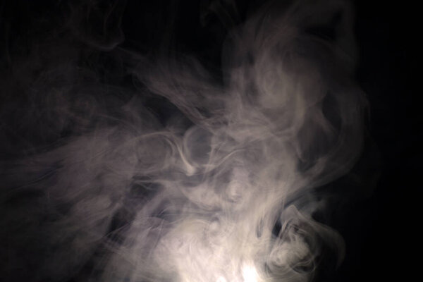 Vague puffs of smoke on a black background. High quality photo