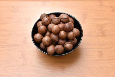 Ahşap bir arka planda siyah bir kasede fındık. Yüksek kalite fotoğraf