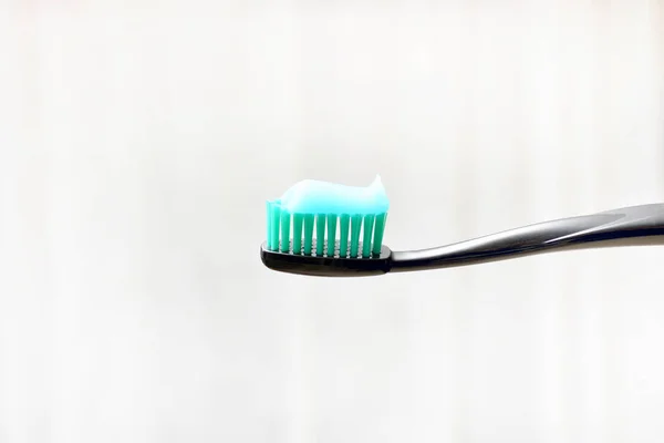 Black Toothbrush Toothpaste Applied Light Background High Quality Photo — Fotografia de Stock