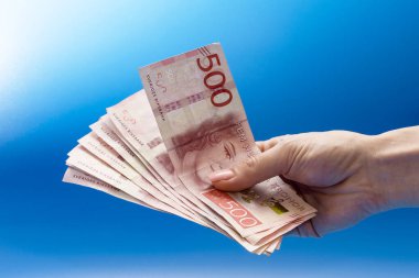 Mavi arka planda bir el dolusu para. İsveç Kroneri 500 mezhebi kapatıyoruz. Yüksek kalite fotoğraf